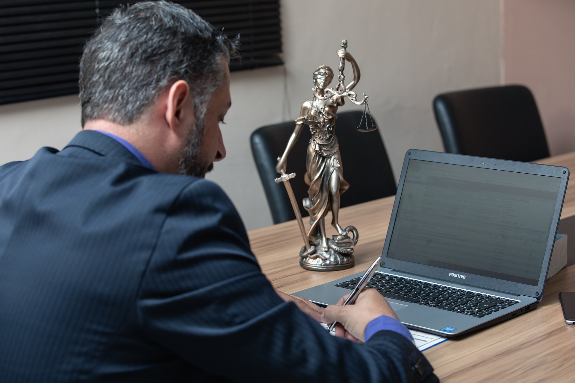 Business Law - Guy with laptop next to lady justice.